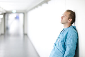 medical professional leaning against a wall after a surgical mistake