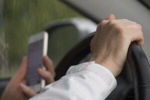 a man texting on his phone while driving a car