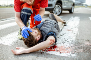medical person checking on a pedestrian laying on the ground after an pedestrian accident