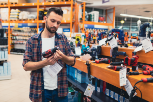man holding a drill at the store. Drills can be an example of a product defect.