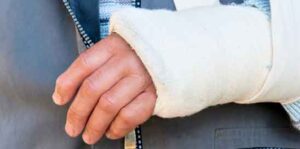 man with a sling on his wrist from a gun wound.