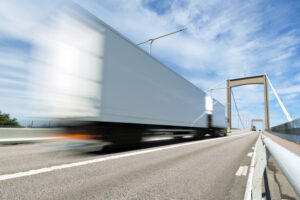 a semi-truck speeding on a bridge